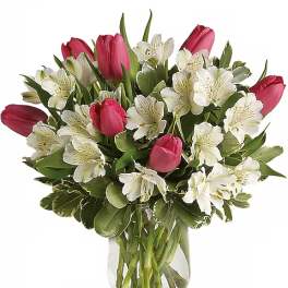 Pink tulips and white alstroemeria in a clear glass vase