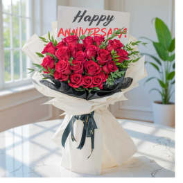 Bouquet of red roses wrapped in white paper with an anniversary card