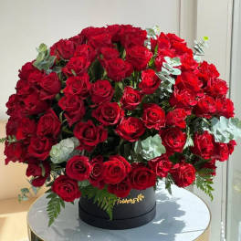 Large bouquet of red roses in a black round box