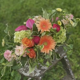 Mixed bouquet with orange gerbera daisies, roses, and pink blooms