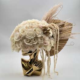 Cream rose bouquet in a gold sculptural vase with dried pampas accents