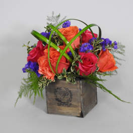 Mixed roses in a wooden box with green decorative loops