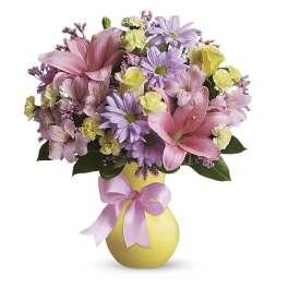 Pink and lavender bouquet in a yellow vase with a pink ribbon