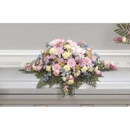 Pastel floral casket spray with pink, white, and yellow blooms