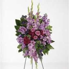 Standing floral spray with purple and pink flowers on an easel