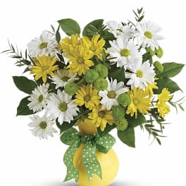 Yellow and white daisy bouquet in a yellow vase with a green ribbon