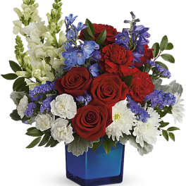 Red roses, white snapdragons, and purple flowers in a blue vase