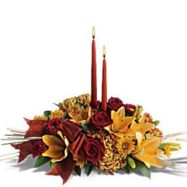 Autumn floral centerpiece with two red taper candles