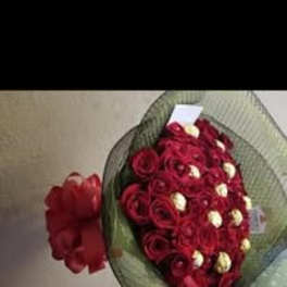 Bouquet of red roses with white accent flowers wrapped in green mesh