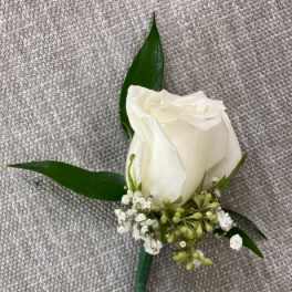 White rose boutonniere with small white filler flowers and green leaves