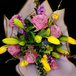 Bouquet of pink roses and yellow tulips with purple accents