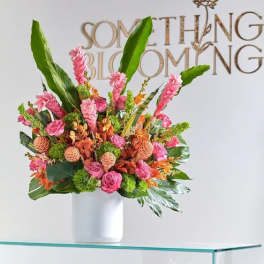 Tropical bouquet in a white vase with pink and orange flowers