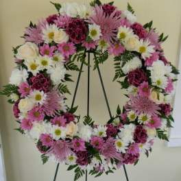 Pink and white floral wreath on a black easel