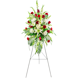 Standing floral spray with red roses and white lilies on an easel