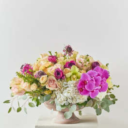 Mixed pink and cream floral arrangement in a pedestal bowl