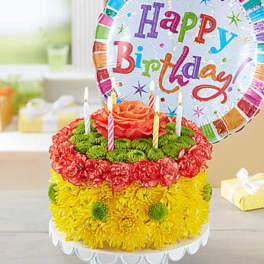 Birthday cake made of flowers with a balloon and candles