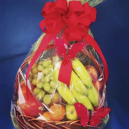 Fruit basket wrapped in clear cellophane with a red bow