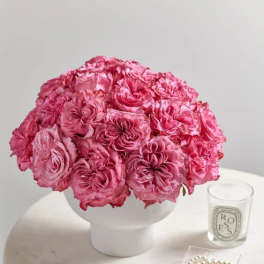 Pink rose bouquet in a white vase on a round table