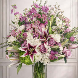 Large bouquet of pink and white flowers in a clear glass vase