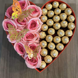 Heart-shaped box with pink roses and gold-wrapped chocolates