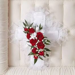 White lace pillow with a red rose bouquet tied on top