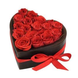 Heart-shaped box filled with red roses and tied with a red ribbon