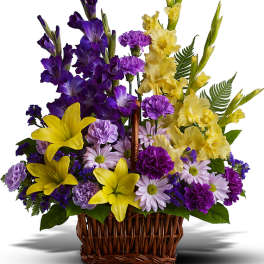 Basket arrangement of purple and yellow flowers with daisies and lilies