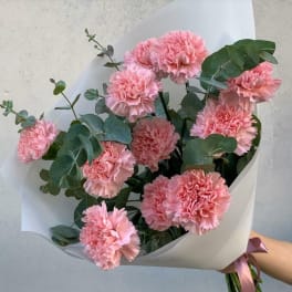 Bouquet of pink carnations with eucalyptus in white wrap
