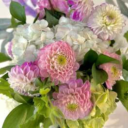 Pink and white flowers arranged with green foliage