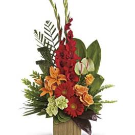 Tropical arrangement with red, orange, and green flowers in a wooden container