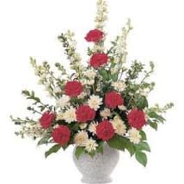 Red and white floral arrangement in a white vase