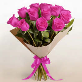 Bouquet of bright pink roses wrapped in paper with a pink ribbon
