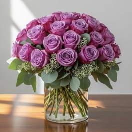 Bouquet of pink and lavender roses in a clear glass vase