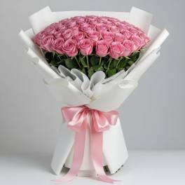 Bouquet of pink roses wrapped in white paper with a pink ribbon