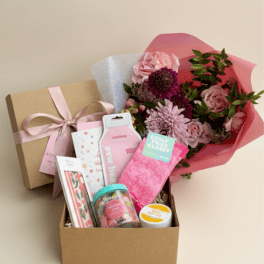 Gift box with pink flowers and assorted self-care items