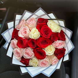 Bouquet of red, pink, and cream roses wrapped in layered paper