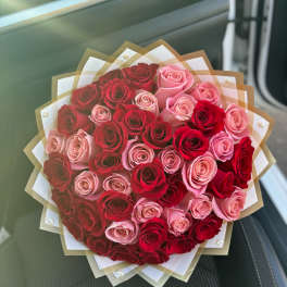 Bouquet of red and pink roses wrapped in layered paper
