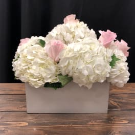 White hydrangeas with pink roses in a rectangular vase