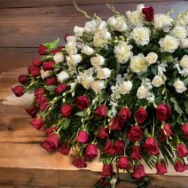 Large arrangement of red and white roses on a wooden surface