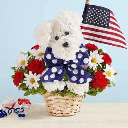 White dog-shaped floral arrangement in a basket with an American flag