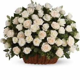 White and blush roses arranged in a wicker basket