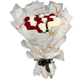 Bouquet of red and white roses wrapped in white paper with gold accents