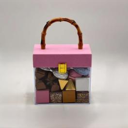 Pink gift box with assorted chocolates and a bamboo handle