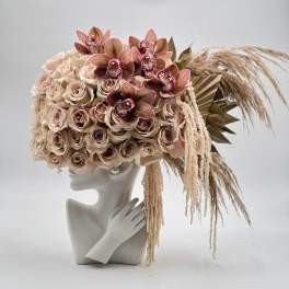 Blush rose and orchid arrangement on a mannequin bust with dried grasses