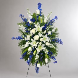 Standing floral spray with white lilies, roses, and blue flowers