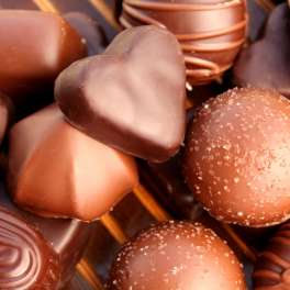 Assorted chocolate truffles, including heart-shaped pieces, in close-up.