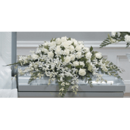 White floral casket spray with roses and lilies