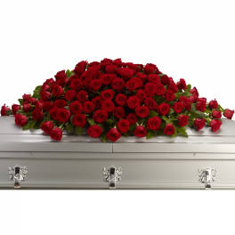 Red rose casket spray on a white casket