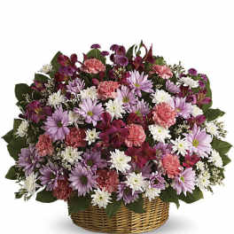 Mixed pink, purple, and white flowers in a wicker basket