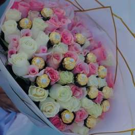 Bouquet of pink and white roses with gold-wrapped chocolates